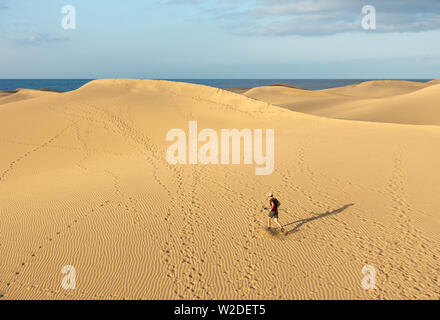 62 enne trail runner il training su vaste dune di sabbia a Maspalomas a Gran Canaria a sunrise. Foto Stock