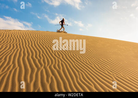 62 enne trail runner il training su vaste dune di sabbia a Maspalomas a Gran Canaria a sunrise. Foto Stock