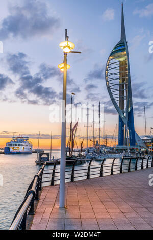 Portsmouth, Hampshire, Inghilterra. Dopo una calda ed umida giornata di Hampshire costa, le luci si accendono al Gunwharf Quays come il sole tramonta su Portsmouth Foto Stock