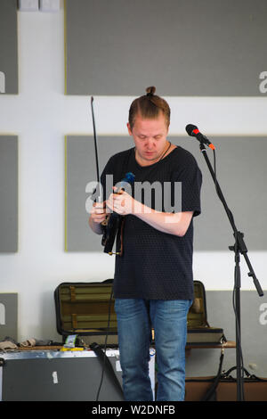 Direttore artistico del Festival, Pekka Kuusisto dando una strada libera concerto con violino elettrico e materiale improvvisato in Järvenpää, Finlandia Foto Stock