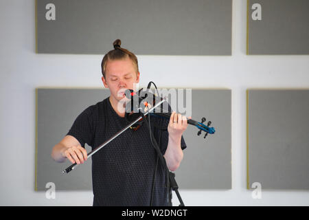 Direttore artistico del Festival, Pekka Kuusisto dando una strada libera concerto con violino elettrico e materiale improvvisato in Järvenpää, Finlandia Foto Stock