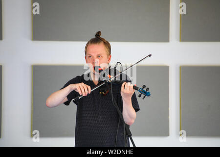 Direttore artistico del Festival, Pekka Kuusisto dando una strada libera concerto con violino elettrico e materiale improvvisato in Järvenpää, Finlandia Foto Stock