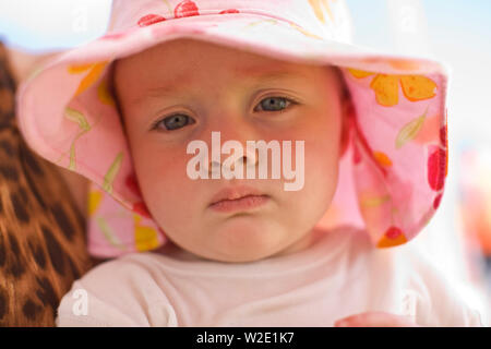 Ritratto di un giovane bambino indossando un cappello floreale mentre all'esterno. Foto Stock