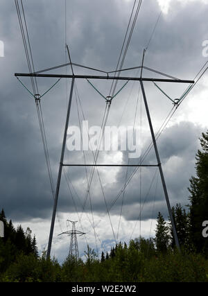 Linea di potenza contro la tempesta grigio e le nuvole nel cielo Foto Stock