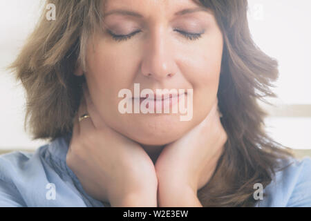 Donna pratica self Reiki con trasferimento di energia attraverso le palme, una sorta di medicina energetica. Foto Stock