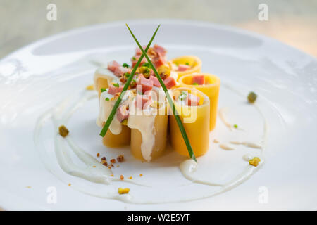 Paccheri fresco italiano la pasta tradizionale con la mortadella Bologna prosciutto cotto, formaggio, crema, i pistacchi,bellissima guarnire la placcatura d'arte chef professionale ammenda Foto Stock