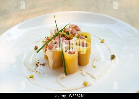 Paccheri fresco italiano la pasta tradizionale con la mortadella Bologna prosciutto cotto, formaggio, crema, i pistacchi,bellissima guarnire la placcatura d'arte chef professionale ammenda Foto Stock