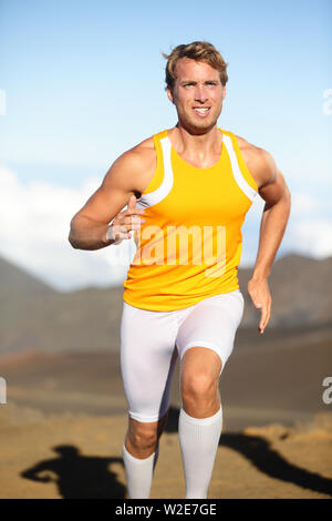 Sport fitness con uomo che corre in volata al di fuori. Runner atleta di esercitare nella bellissima natura all'esterno. Montare muscolare modello maschile della formazione per la maratona come parte di uno stile di vita sano. Giovane ragazzo bello, 20s Foto Stock