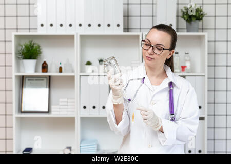 L'infermiera si prepara un contagocce con una soluzione di medicina. Foto Stock