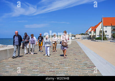 Anziani turisti a piedi lungo la passeggiata a mare resort Wissant in estate lungo la Côte d'Opale, Pas-de-Calais, Hauts-de-France, Francia Foto Stock