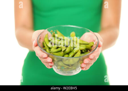 I fagioli di soia - cibo sano. La donna che mostra sano fresco verde fagiolo edamame.i semi di soia in stretta fino isolato su sfondo bianco in studio. Foto Stock