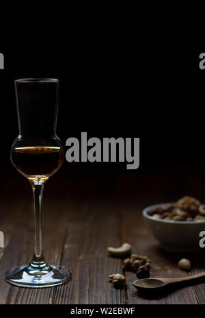 Bicchiere di whiskey sul vecchio tavolo in legno con dadi e candela in autunno umore nel buio Foto Stock