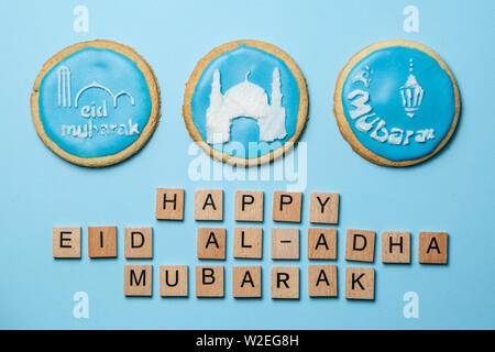 EID al-Adha Mubarak concetto di vacanza - biscotti blu con foto stenciled Foto Stock