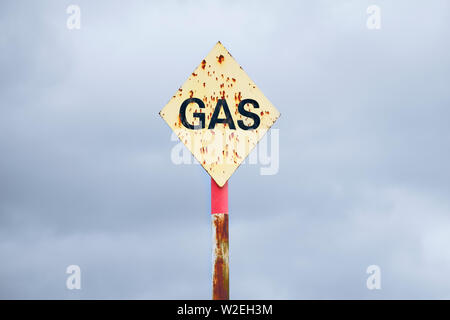 Giallo Gas rusty segno posto contro il grigio nuvole nel cielo Foto Stock