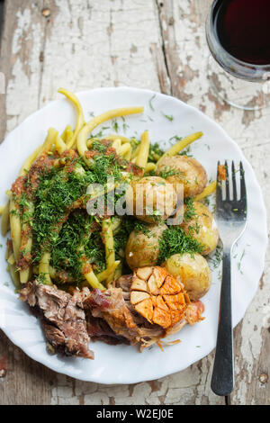 Arrosto di maiale con fagiolini e patate baby Foto Stock