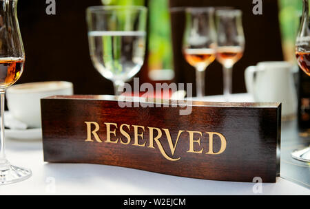 Riservato in legno piastra su un ristorante convenzionato tabella Foto Stock