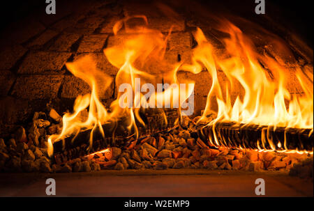 Le fiamme di un forno a legna con tizzi e la combustione di legna Foto Stock
