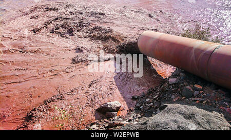 Le acque reflue industriali viene scaricato dal tubo nell'acqua. Foto Stock