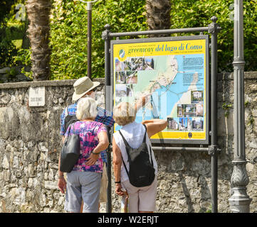 LENNO, LAGO DI COMO, Italia - Giugno 2019: le persone che ricercano una mappa della Greenway del lago di Como a Lenno sul Lago di Como. La Greenway è un itinerario a piedi Foto Stock