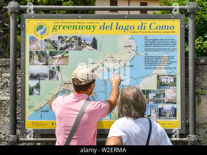 LENNO, LAGO DI COMO, Italia - Giugno 2019: le persone che ricercano una mappa della Greenway del lago di Como a Lenno sul Lago di Como. La Greenway è un itinerario a piedi Foto Stock