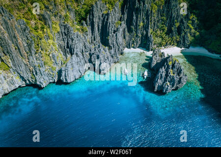 El Nido, PALAWAN FILIPPINE. Antenna vista sopra di banca barche circondato da paesaggi carsici le rocce in Secret Lagoon Beach Foto Stock