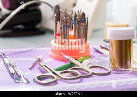 Un set di frese per il dispositivo per manicure e strumenti per la cura delle unghie sul tavolo Foto Stock