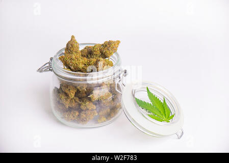 Dettaglio delle gemme di cannabis su chiari vasetti di vetro isolato su bianco - la marijuana medica del dispensario del concetto Foto Stock