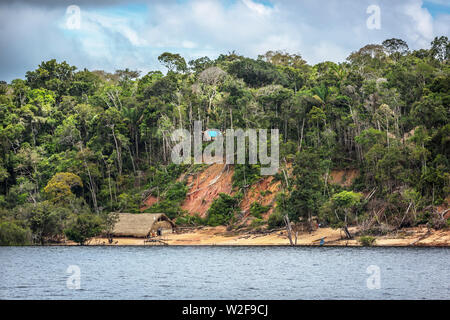 Un area di deforestazione in bordo del Fiume Rio delle Amazzoni con una tradizionale casa indigena in Amazzonia stato in Brasile Foto Stock