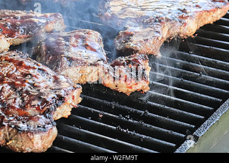 Primo piano di bistecche cottura su un barbecue Foto Stock