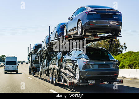 Luglio 4, 2019 Redwood City / CA / STATI UNITI D'AMERICA - Car transporter porta Tesla Modello 3 nuovi veicoli lungo l'autostrada a San Francisco Bay Area, vista posteriore del th Foto Stock