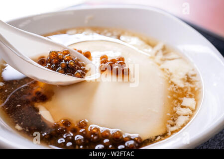Popolari Taiwan gourmet - Dessert di tapioca pearl sfera (bolla) mescolato tofu budino di tofu (douhua, dou hua) in bianco ciotola, close up, lo stile di vita Foto Stock