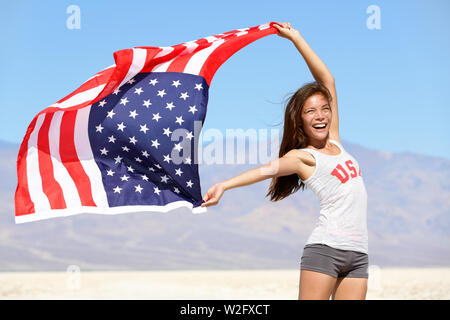 Bandiera americana - donna usa sport atleta vincitore tifo sventolare a stelle e strisce outdoor dopo nella natura del deserto. Bellissimo il tifo felice giovane ragazza multiculturale gioioso ed entusiasta. Foto Stock