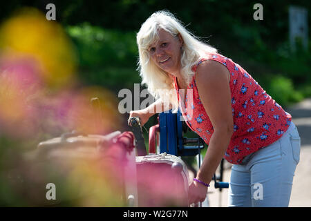 Wahmbeck, Germania. 17 Giugno, 2019. Petra Helga Ilsenann, ferrywoman del Weser Wahmbeck traghetto, opera una manovella sulla fune di imbardata del traghetto, che commuta tra la Bassa Sassonia Wahmbeck cittadina e la città di Hesse Gewissenruh sul Weser. (Per dpa estate serie 'Vivere e lavorare sul fiume') Credito: Swen Pförtner/dpa/Alamy Live News Foto Stock