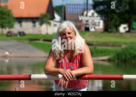 Wahmbeck, Germania. 17 Giugno, 2019. Petra Helga Ilsenann, ferrywoman del Weser Wahmbeck traghetto, sorge sulla fune di imbardata del traghetto, che viaggia tra la Bassa Sassonia Wahmbeck cittadina e la città di Hesse Gewissenruh sul Weser. (Per dpa estate serie 'Vivere e lavorare sul fiume') Credito: Swen Pförtner/dpa/Alamy Live News Foto Stock