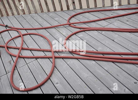 Il tubo flessibile rosso sul ponte di cedro Foto Stock