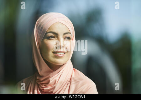 Ritratto di ambizioni sognante sorridente giovane donna in hijab guardando lontano Foto Stock