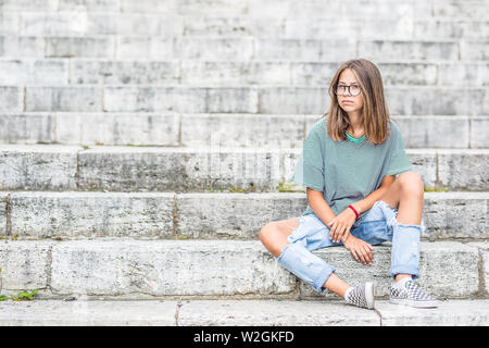 Portraito della ragazza in un libero moderno vestito da jeans con fori. Foto Stock