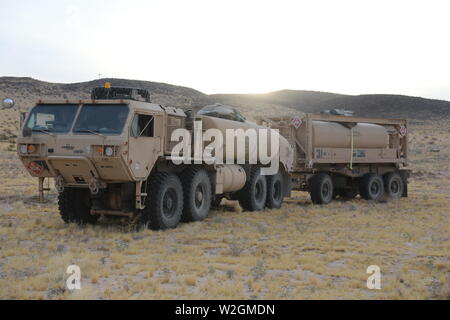 I soldati del primo squadrone, 150° reggimento di cavalleria, 30 vigili del Team di combattimento, West Virginia Guardia nazionale, utilizzare una pesante Mobilità Estesa Tactical carrello per trasportare il carburante per sete serbatoi, HMMWVs e altri veicoli tattici durante il funzionamento Hickory Sting a Fort Irwin, California, il 7 luglio 2019. Funzionamento Hickory pungiglione è una decisa azione rotazione incentrato sulla produzione combinata di bracci e manovra gunnery collettiva presso il Centro Nazionale di Allenamento, Fort Irwin, California, al fine di convalidare le capacità del trentesimo nell'ambiente di formazione e fornire globalmente un sensibile brigata pronto per distribuire, f Foto Stock