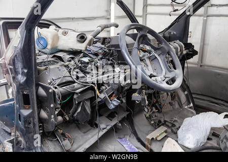 Per interni auto nel retro di un furgone con un cruscotto smontato e vista sul volante durante la preparazione di un veicolo officina di riparazione. Auto servi Foto Stock
