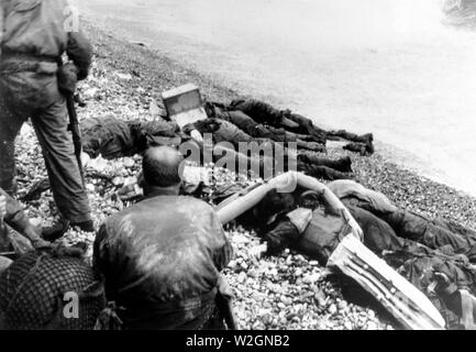 [Didascalia originale] American assalto delle truppe della terza Bat., XVI Regt., 1US Inf. Div., che hanno fallito nel loro tentativo di tempesta attraverso una stretta striscia di spiaggia a Collville Sur Mer, Normandia, per la sicurezza di confronto di un gesso scogliera a poche centinaia di metri dal surf. La spiaggia di Omaha, Francia 6 Giugno 1944 Foto Stock