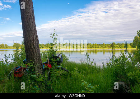 Moto turistiche sulla costa ricoperta di un piccolo lago su una soleggiata giornata estiva, Russia. Foto Stock