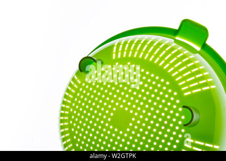 Close-up di un verde scolapasta plastica, un arnese da cucina a scolare la pasta su uno sfondo bianco. Foto con copia spazio. Foto Stock