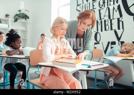 Insegnante aiutando il suo allievo durante la lezione. Foto Stock