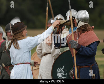 Femmina portatore di acqua dando acqua per guerrieri. Foto Stock