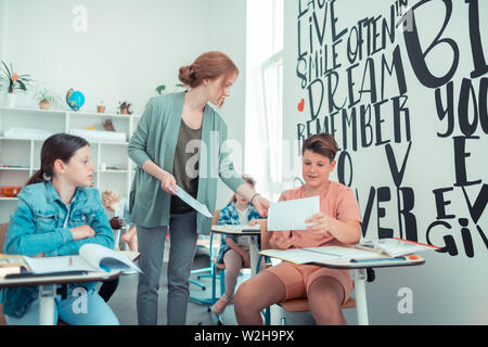 Scolaro chiedendo il suo insegnante relative al test. Foto Stock