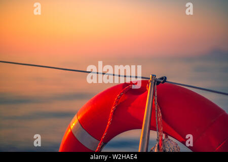 Salvagente sul ponte di una nave in mare a Sunrise Foto Stock