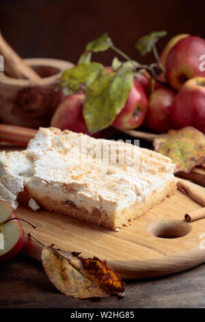 Freschi di forno delizioso classic American apple pie. Mele, bastoncini di cannella e utensili da cucina su un vecchio tavolo di legno. Foto Stock