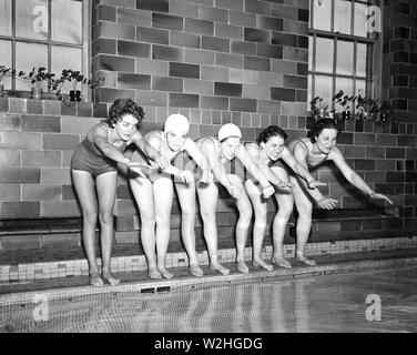 Donne nuotatori preparando per immergersi in una piscina di ca. 1936 Foto Stock