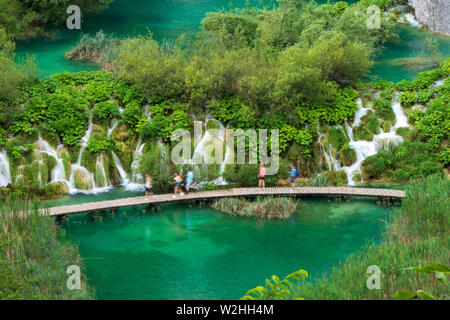 Correndo pura acqua fresca cascate giù le barriere naturali nell'azzurro lago colorato Kaluđerovac presso il Parco Nazionale dei Laghi di Plitvice in Croazia Foto Stock