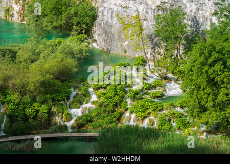 Correndo pura acqua fresca cascate giù le barriere naturali nel colore turchese Lago Kaluđerovac presso il Parco Nazionale dei Laghi di Plitvice in Croazia Foto Stock